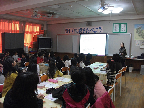 小学校の教室で開催されている「ツボミスクール」の様子。熱心に聞き入る女の子たち。