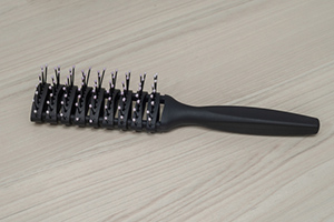 Black,Plastic,Hairbrush,On,Wooden,Table
